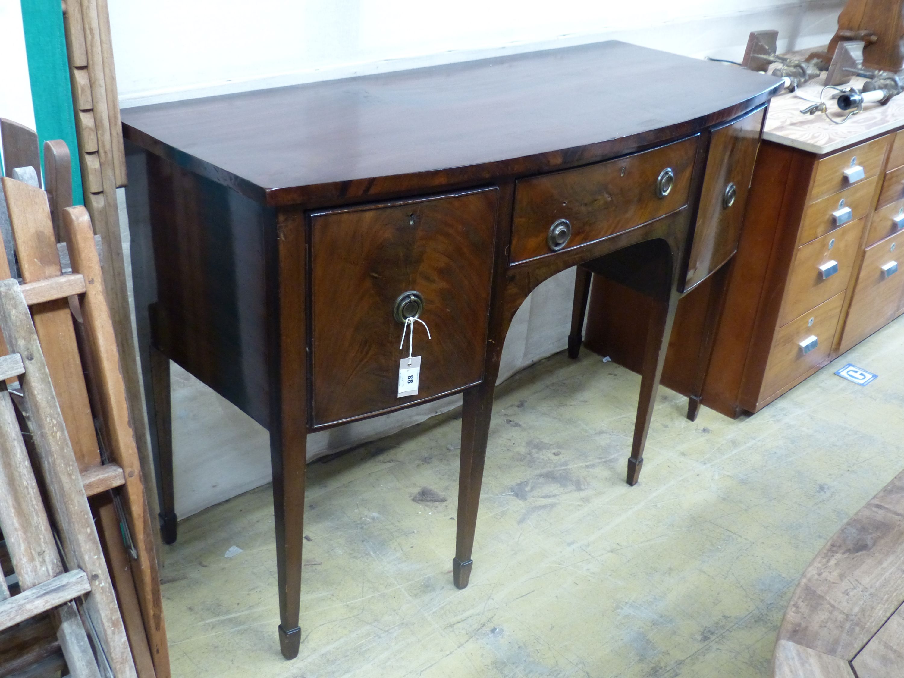 A late 19th century Sheraton style mahogany bowfront sideboard, fitted three drawers, length 140cm, depth 58cm, height 89cm